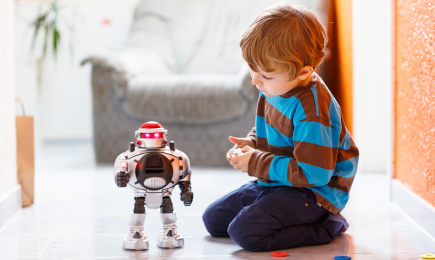 malý chlapec si hraje s hračkou robotem