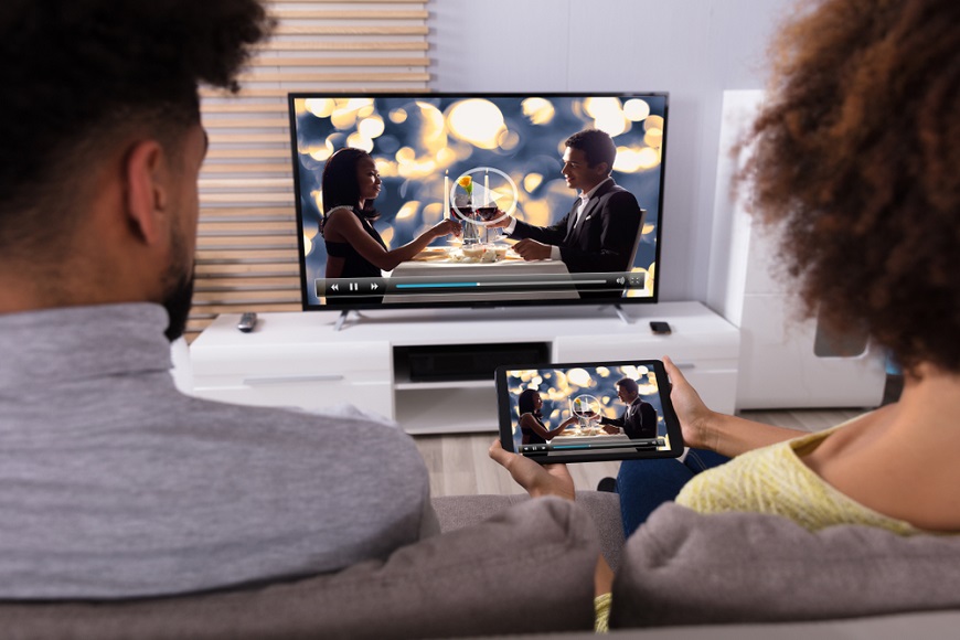 Pár sledující pořad v televizi a přenosném zařízení