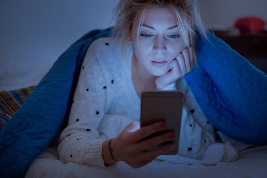 K čemu jsou dobré brýle proti modrému světlu Žena ve tmě používá telefon bez brýlí blokujících modré světlo