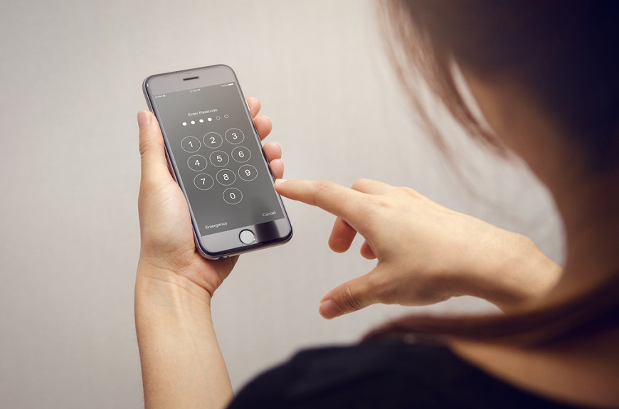 Jak odblokovat telefon? žena vkládá heslo do mobilu