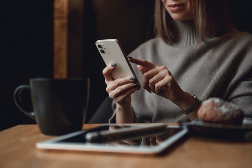 Jak odblokovat telefon? žena drží mobilní telefon u snídaně