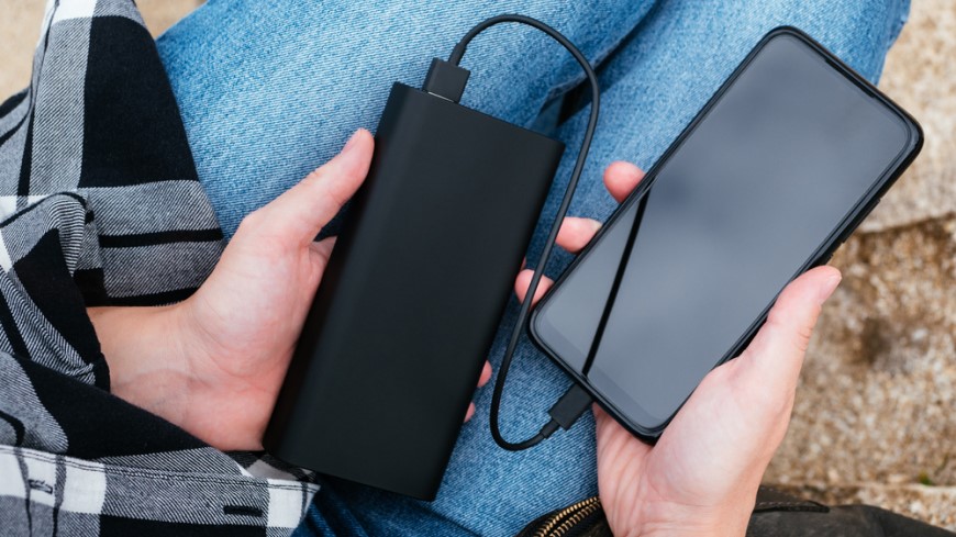 pohled na ruce s mobilem a powerbankou