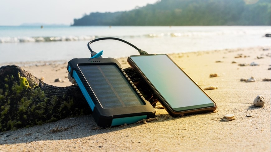 solární powerbanka na pláži dobíjí mobil