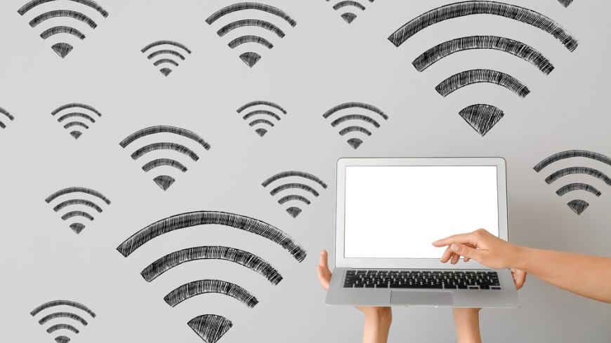 Jak propojit dva routery? Ilustrace MacBooku a Wi-Fi plného signálu
