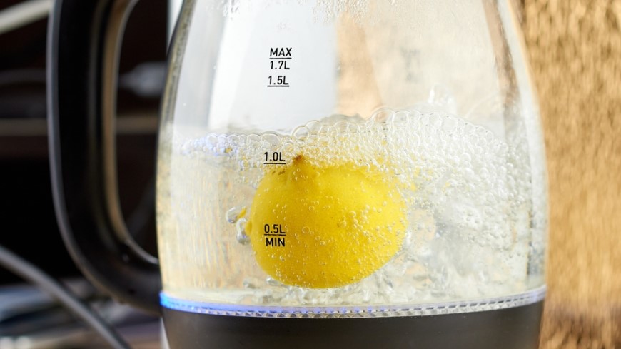 Citron převařující se v rychlovarné konvici pro odstranění vodního kamene