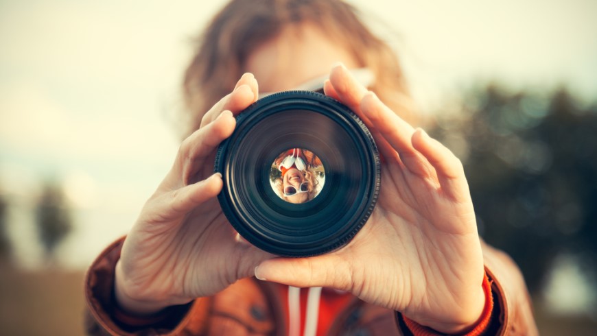 Jak vybrat objektiv? natažené ruce drží objektiv fotoaparátu