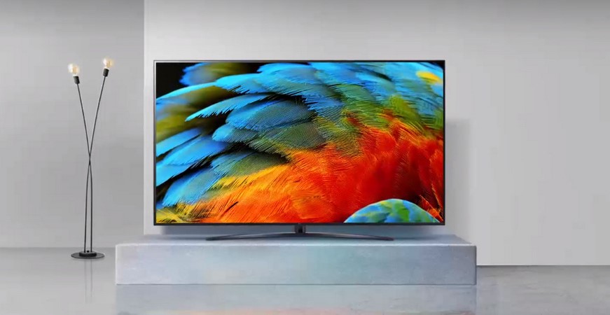 OLED TV umístěná v minimalistickém prostoru s lampou