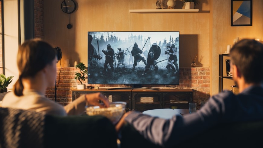 pár jí popcorn a sleduje tv v obývacím pokoji