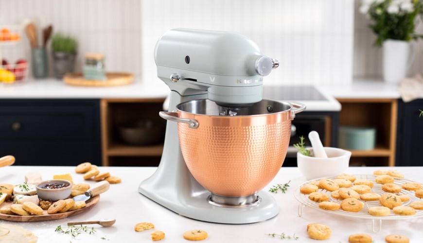 Tipy na dárky pro ženy: Čím udělat radost manželce, mamince, kamarádce nebo třeba sestře? pohled na kuchyňský robot KitchenAid na kuchyňské lince se sušenkami