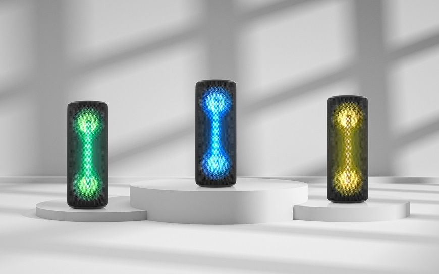 Novinky JVC: Nadupané repro pro každého Tři černé přenosné Bluetooth reproduktory JVC s barevným LED podsvícením v zelené, modré a žluté barvě na bílém podstavci
