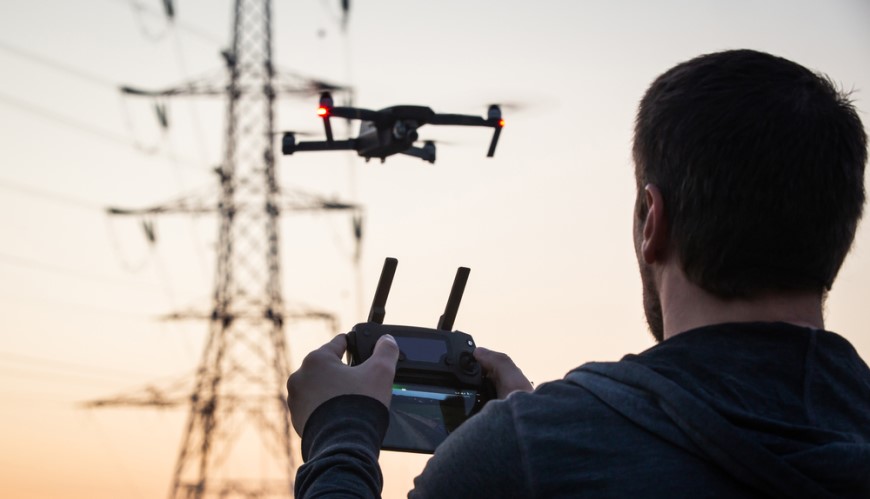 Muž ovládá dron pomocí dálkového ovladače