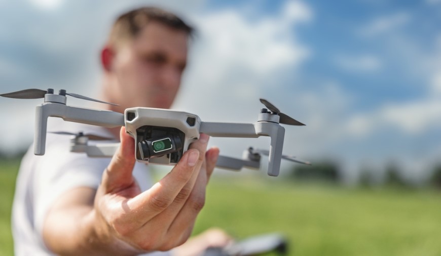 Muž drží v ruce dron