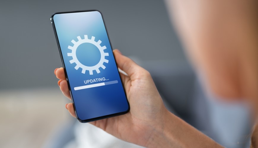Jak aktualizovat Android: Kompletní průvodce a užitečné rady Chytrý mobilní telefon. Na displeji probíhá aktualizace – ozubené kolo a nápis UPDATING.