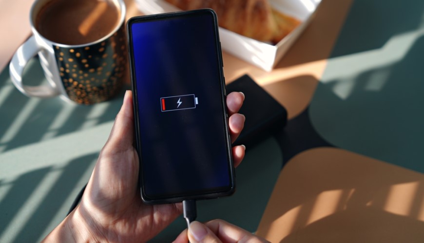 Jak aktualizovat Android: Kompletní průvodce a užitečné rady Mobilní telefon připojený k nabíječce. Na displeji vidíme symbol vybité baterie.