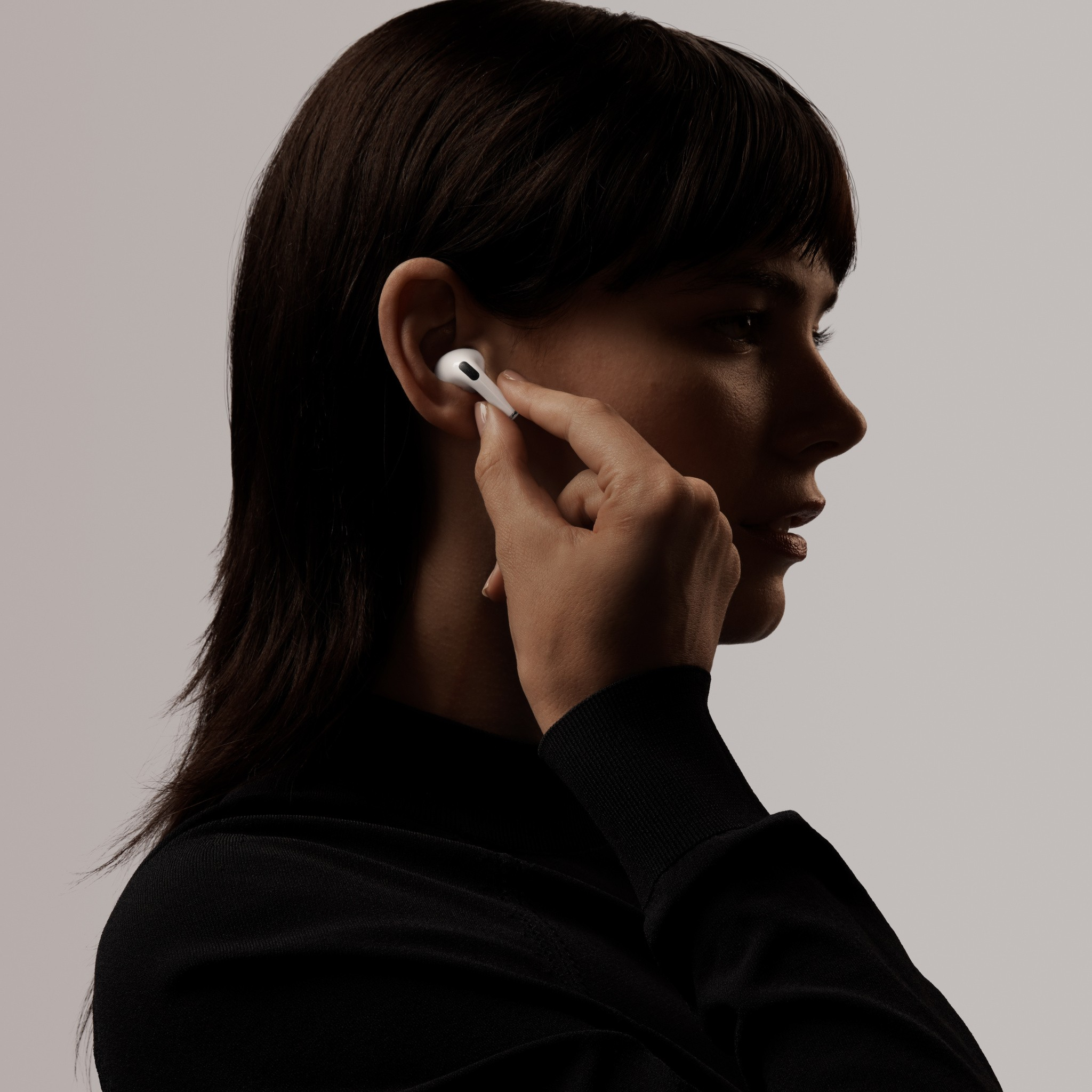 Proč si pořídit AirPods? Žena si nasazuje Apple AirPods