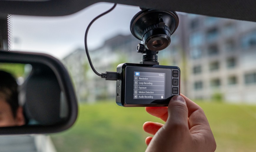 Autokamera s displejem na čelním skle, uchycená pomocí přísavky.