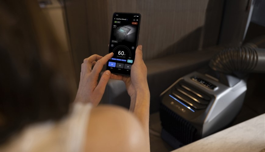 Jak vybrat klimatizaci? Nespleťte si ji s pouhým ochlazovačem Žena pomocí chytrého telefonu a mobilní aplikace nastavuje klimatizaci