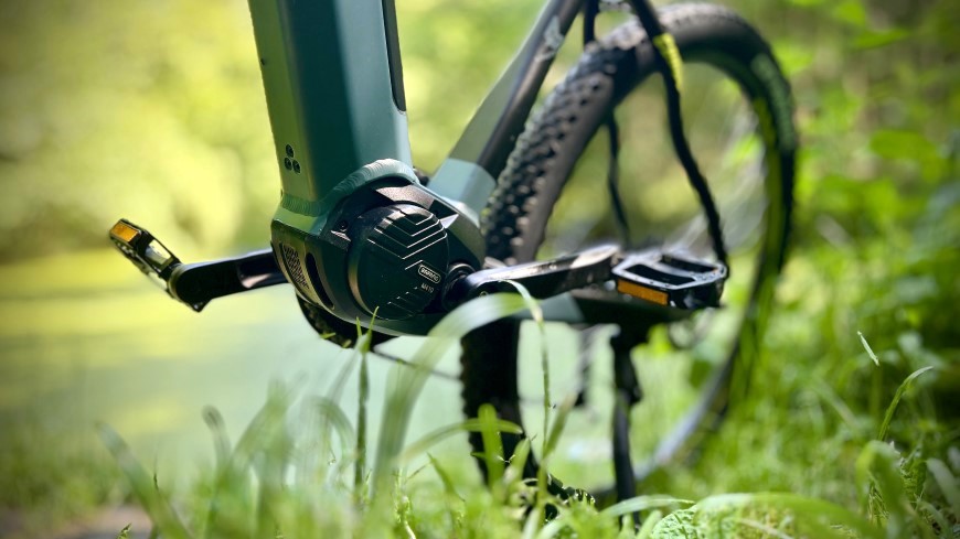 Recenze: Elektrokolo GoGEN Campo MX 720 – Když srdce velí Go a dobrodružství máte v GENech Horské elektrokolo GoGEN Campo MX 720 v terénu – detail pedálů a pohonné jednotky kola v jeho středu