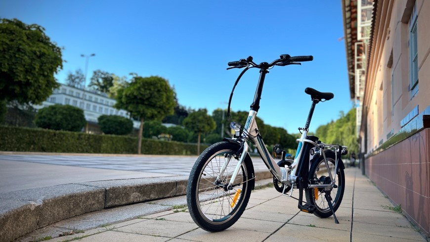 Skládací elektrokolo GoGEN Lumion, opřené o stojan