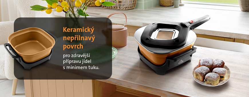 Pečenky ETA Ceramic Natura: Když pečení hraje barvami Elektrický pečicí hrnec ETA PEČENKA s béžovým keramickým nepřilnavým povrchem pro zdravější vaření s minimem tuku postavený na jídelním stole vedle Honzových buchet