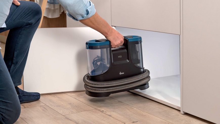 osoba dává Čistič koberců Hoover HS500 011 do malé skříňky