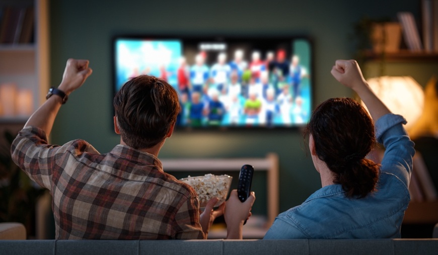 Jak si užít sport na maximum aneb Průvodce elektronikou pro opravdové fanoušky Mladý pár, který fandí svému oblíbenému fotbalovému týmu doma u televizní obrazovky.