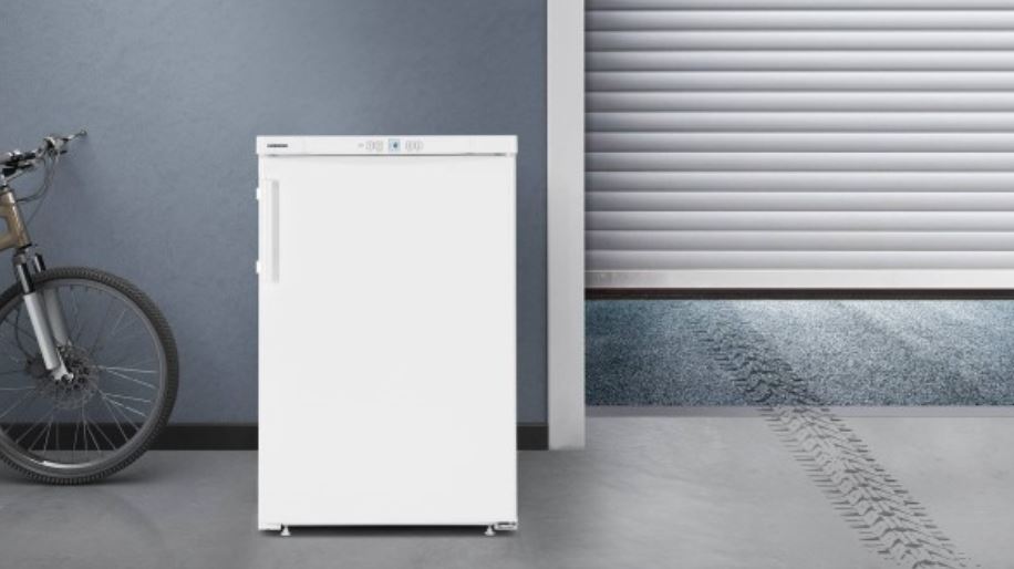 Jak funguje NoFrost mrazáků Liebherr? Srovnání beznámrazových a SmartFrost modelů malá bílá šuplíková mraznička liebherr umístěná v chladném prostředí v garáži. Vedle ní stojí jízdní kolo, z druhé strany jsou skoro zavřená vrata.