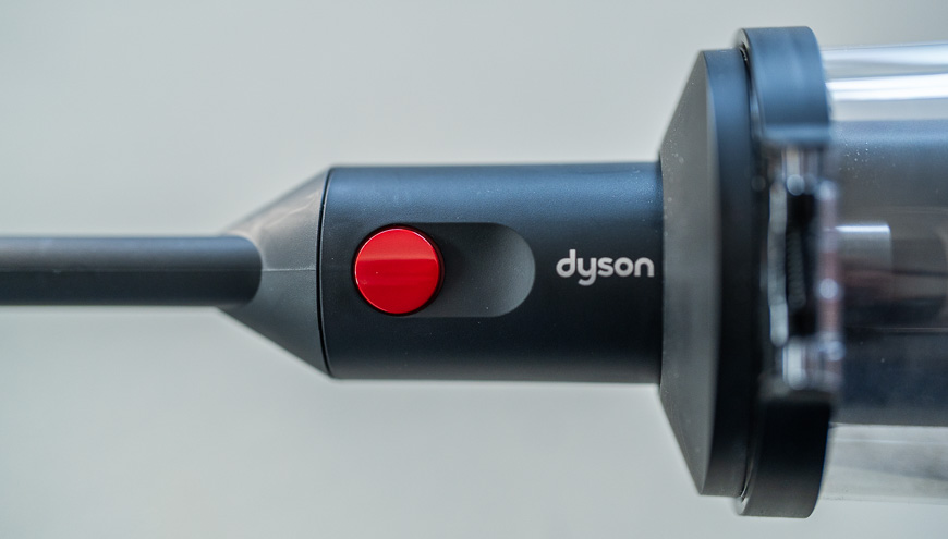 Recenze: Tyčový vysavač Dyson V16 Piston Animal Submarine™ – Expert na podlahy 3 v 1 Záběr na červené tlačítko tyčového vysavače Dyson V16 Piston Animal Submarine™