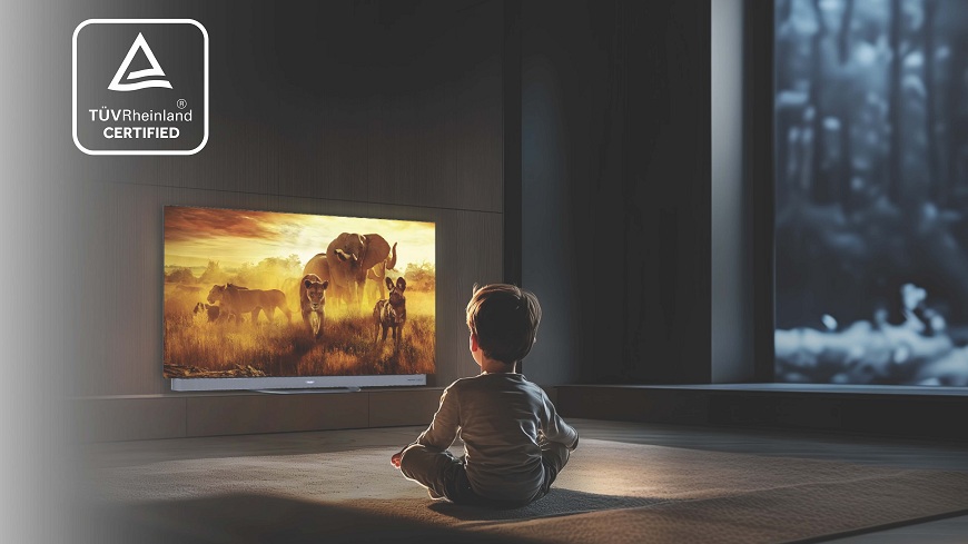 dítě sedí v potemnělé místnosti a hledí na televizi, která svítí žlutě. vlevo nahoře je logo certifikace tüv