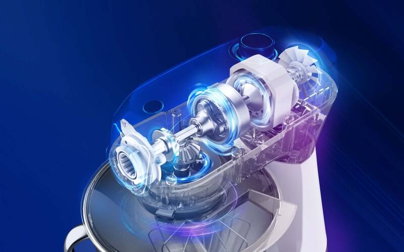 Rentgenový průhled do vnitřní konstrukce kuchyňského robotu ETA Gratus Storio II zobrazující kovová převodová kola a výkonný motor s modrým podsvícením