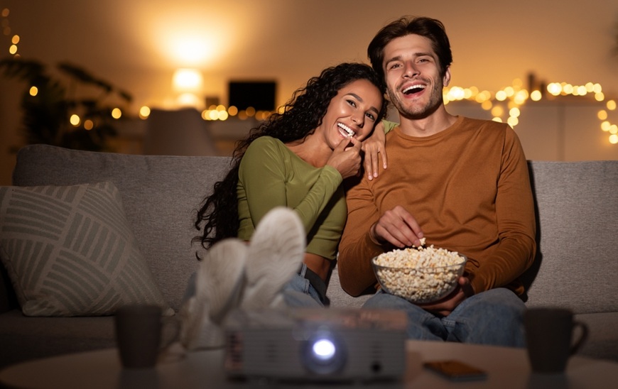 pár sleduje film a pojídá popcorn