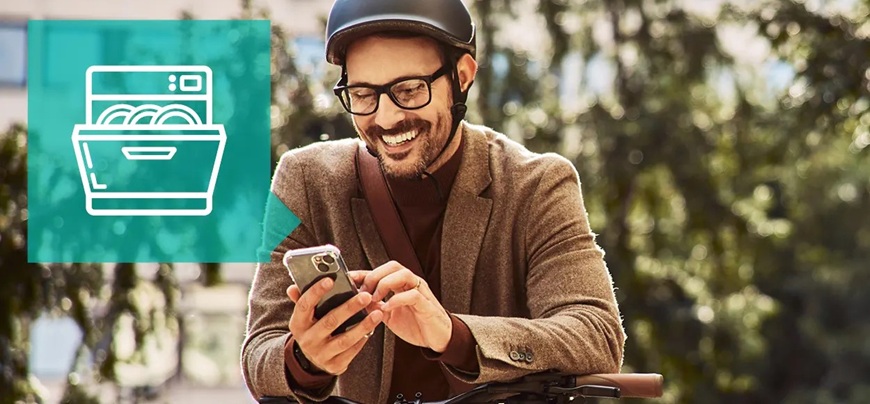 Muž ovládá svou myčku dálkově díky mobilní aplikaci ConnectLife.