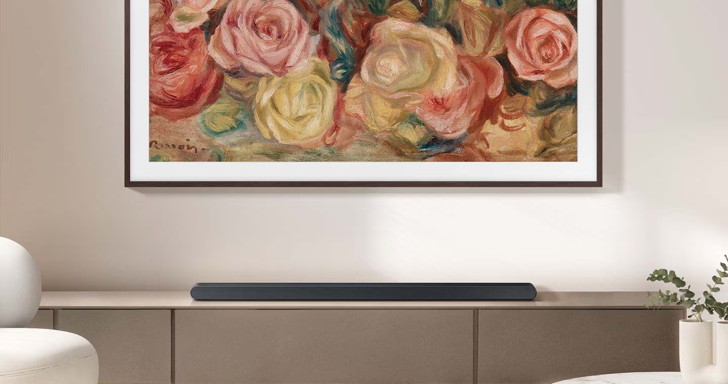 Lifestylová kolekce Samsung: Designové televizory a soundbary, které zkrášlí váš domov Soundbar Samsung HW-S700D leží na skříňce pod televizí, na jejíž obrazovce je umělecké dílo