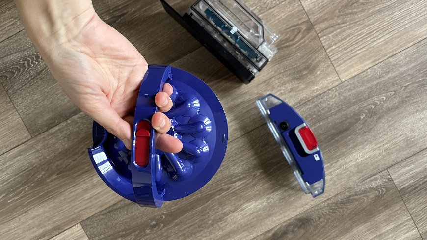 Recenze: Dyson Spot+Scrub™ AI – Chytrý úklid pro každodenní chaos Žena držící vyjímatelný filtr robotického vysavače