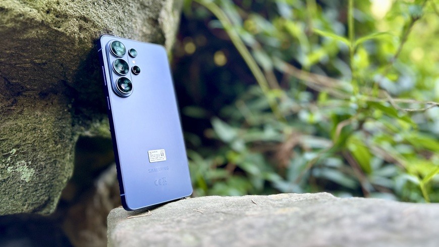 Záběr na zadní stranu smartphonu Samsung Galaxy S26 Ultra ve fialovém provedení, opřeného o skálu