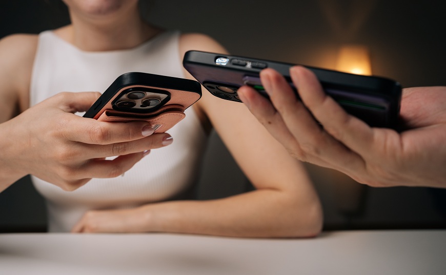 Vše o mobilech: 10 otázek, na které se ptáte nejčastěji Dva lidé drží mobily u sebe pro přenos dat.