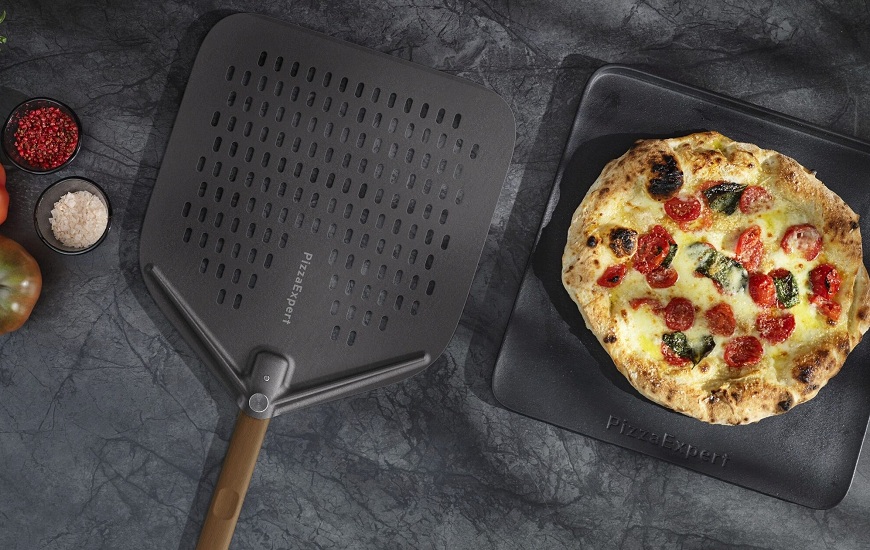 Nová trouba AEG PizzaExpert: Pizza jako z Neapole jen za 2,5 minuty Litinový plech a perforovaná lopatka na pizzu AEG. Na plechu je neapolská pizza.