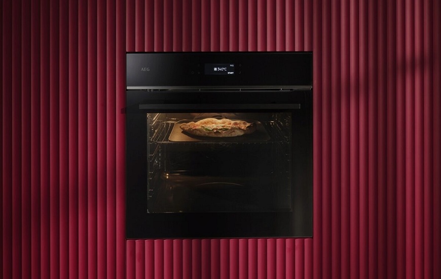 Nová trouba AEG PizzaExpert: Pizza jako z Neapole jen za 2,5 minuty Trouba AEG PizzaExpert v kuchyni s červeným dekorem.