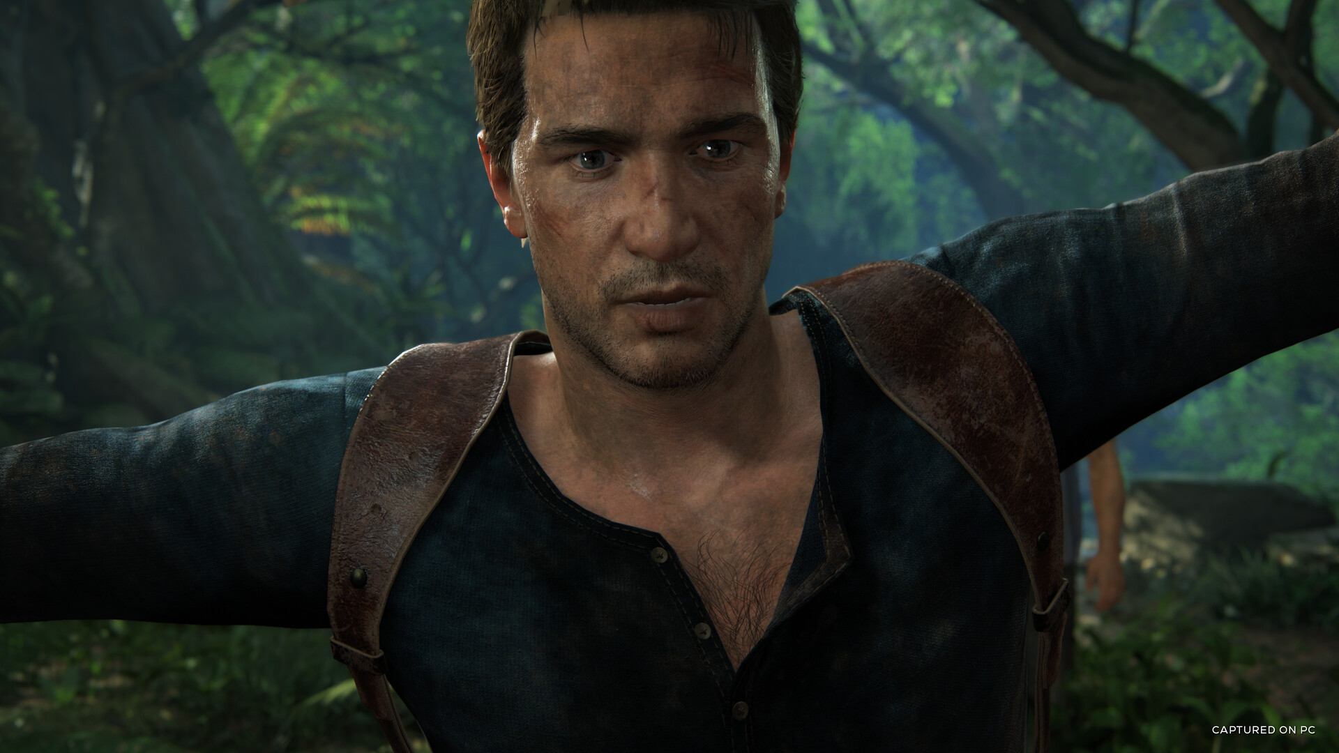Nathat Drake na pozadí stromů, screenshot ze hry Uncharted