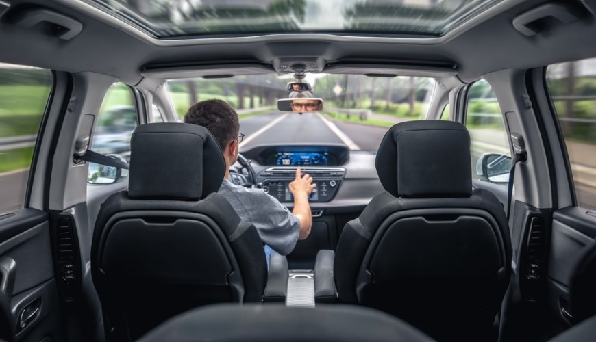 Jak spárovat telefon s autem: Průvodce, se kterým to zvládnete za 2 minuty Muž řídí auto a ovládá dotykovou obrazovku