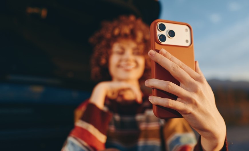 Jak spárovat telefon s autem: Průvodce, se kterým to zvládnete za 2 minuty Žena se fotí na iPhone 17 Pro s oranžovým krytem