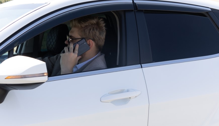 Jak spárovat telefon s autem: Průvodce, se kterým to zvládnete za 2 minuty Muž telefonuje v autě