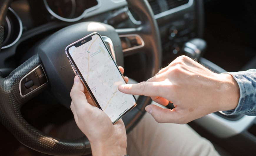 Jak spárovat telefon s autem: Průvodce, se kterým to zvládnete za 2 minuty Muž si nastavuje na telefonu navigaci