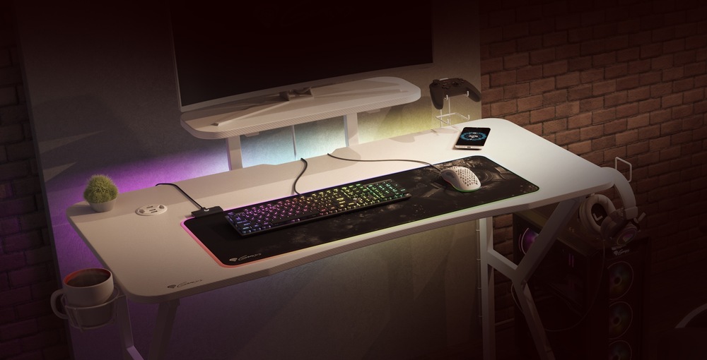 Na herním stole stojí monitor na polici, na desce stolu je položena klávesnice a myš na podložce, stůl má RGB podsvícení