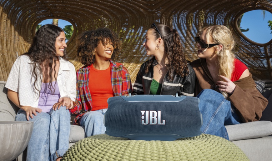 parta přátel a v popředí reproduktor JBL Xtreme 5