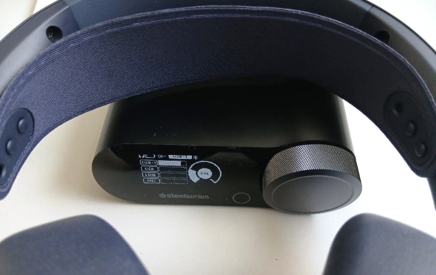 Headset Arctis Nova Pro Omni je položen přes zapnutý GameHub, detail displeje GameHubu
