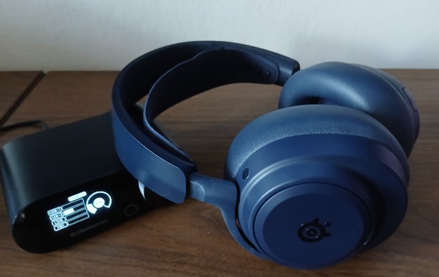 Headset Arctis Nova Pro Omni je položen přes zapnutý GameHub