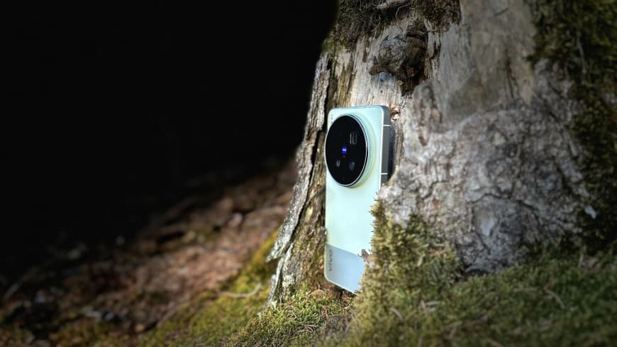 Zadní strana smartphonu vivo X300 Ultra v zeleném provedení, který je zasazen do atmosférického záběru v terénu.