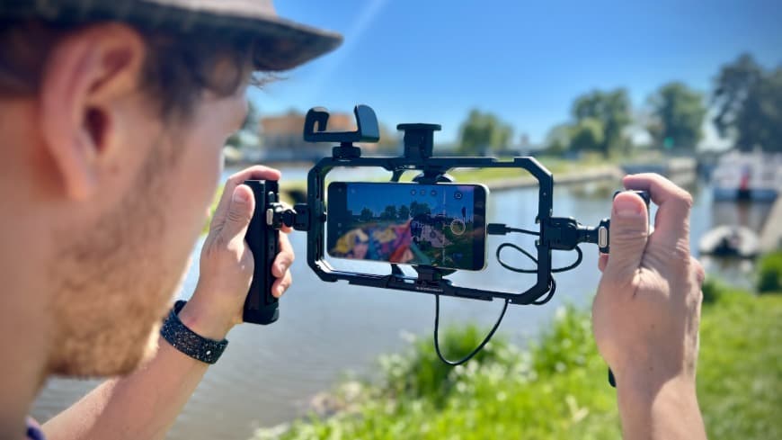 Smartphone vivo X300 Ultra, ukotvený v kamerové kleci vivo SmallRig Pro Video Rig Kit při natáčení v terénu.