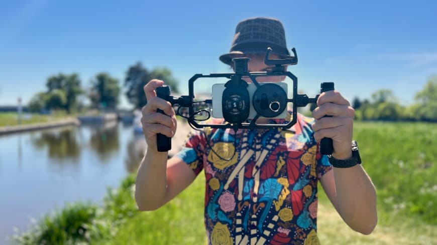 Smartphone vivo X300 Ultra, ukotvený v kamerové kleci vivo SmallRig Pro Video Rig Kit při natáčení v terénu.